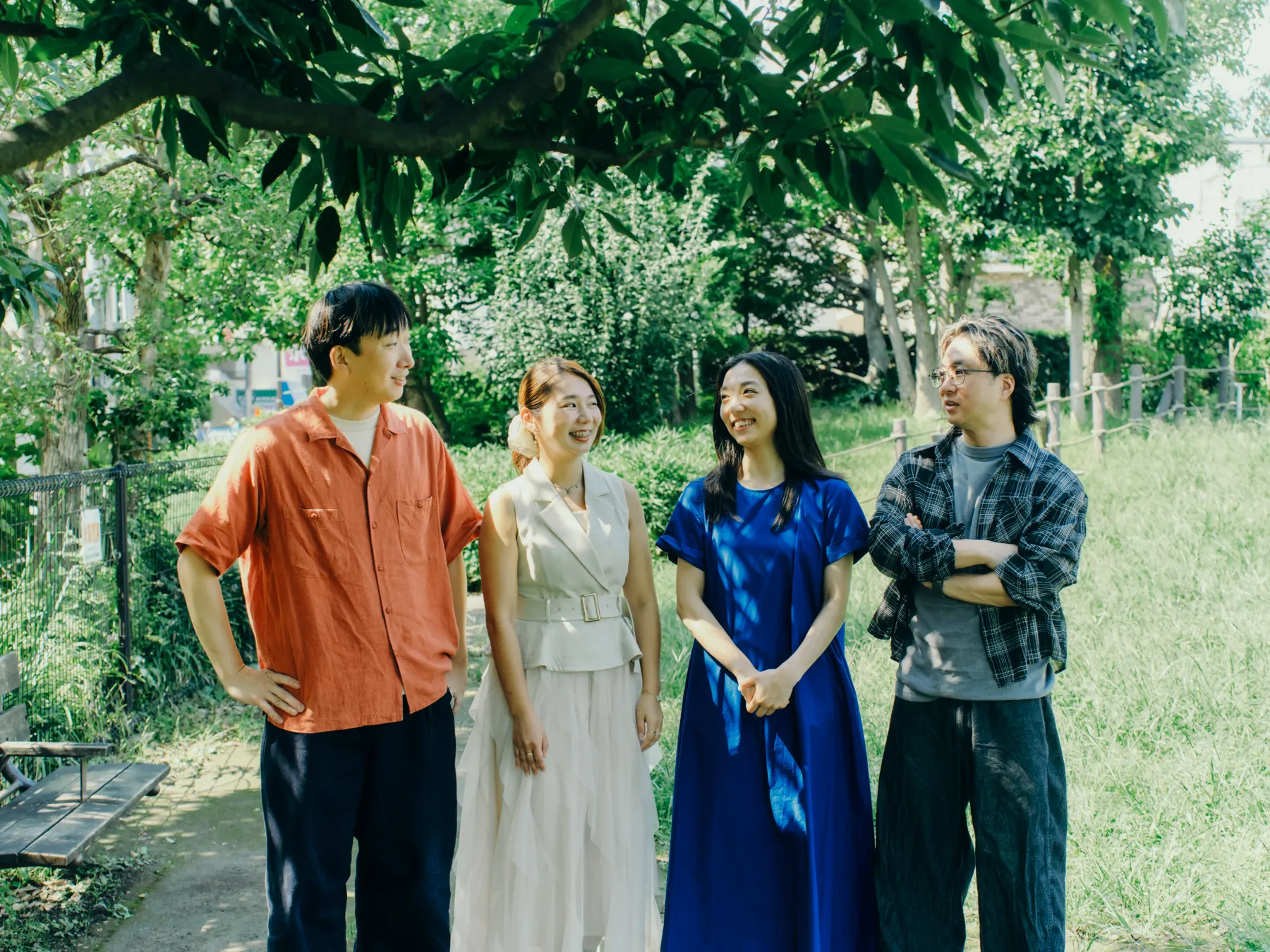 代沢せせらぎ公園の木陰で笑い合う dot button company のメンバー4人