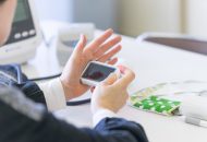 計測機器を手に持ち健康データを測定する参加者の手元