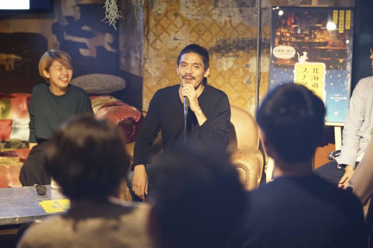 スナック風にしつらえた会場で語らうゲストと参加者｜移住イベントの様子