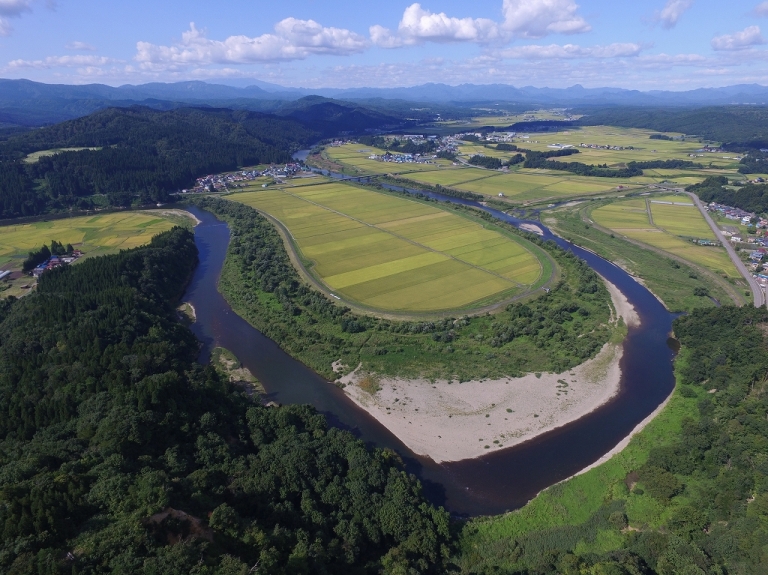 山形県鮭川村を流れる川と田園風景の空撮